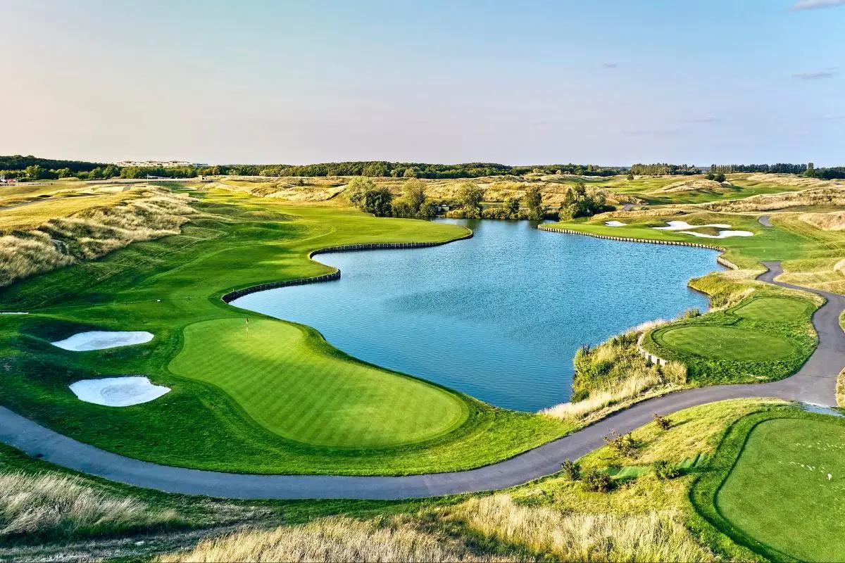 Overhead view of a smooth green sandwiched by sand bunkers and a water hazard