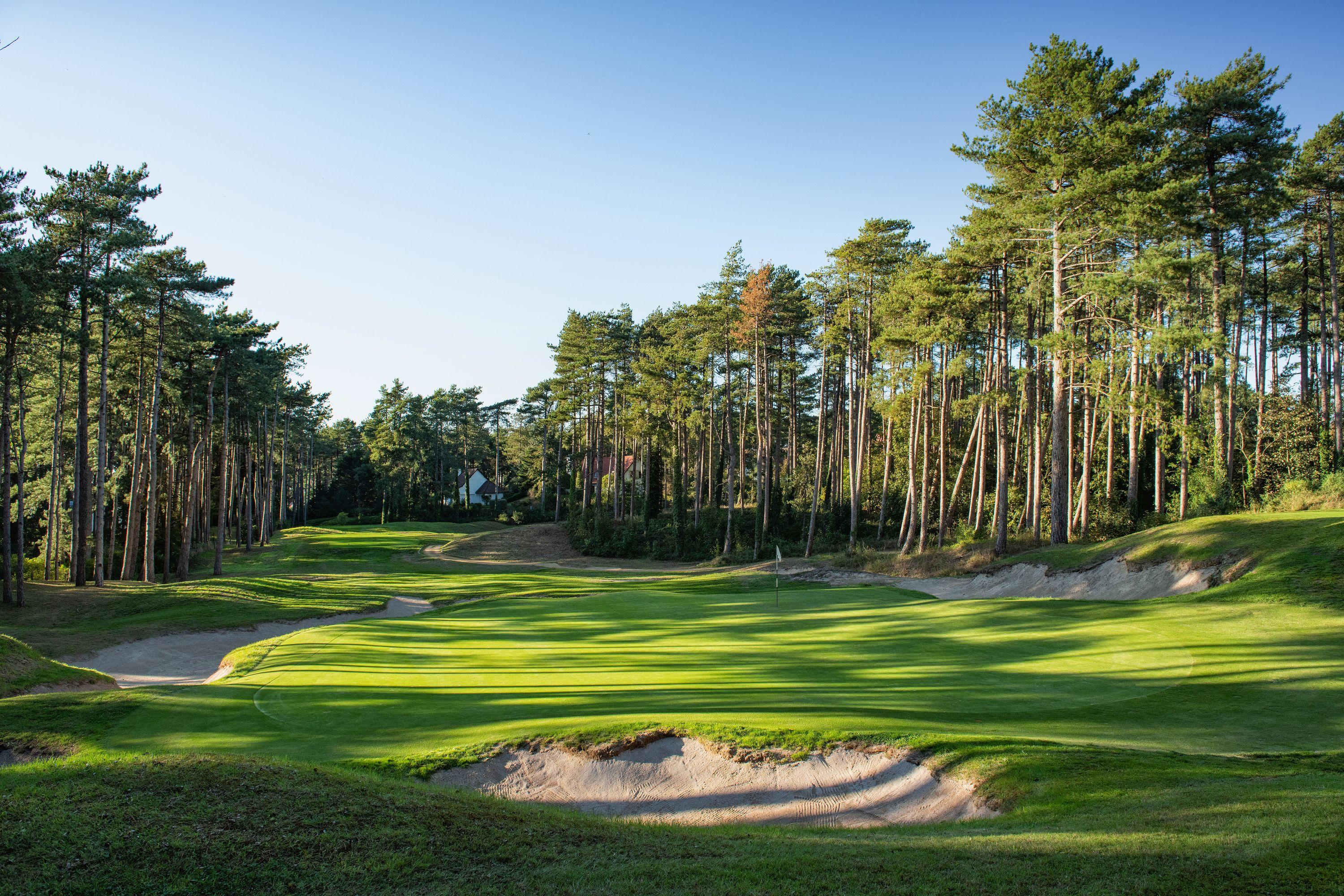 A well maintained fairway nestled with sand bunkers