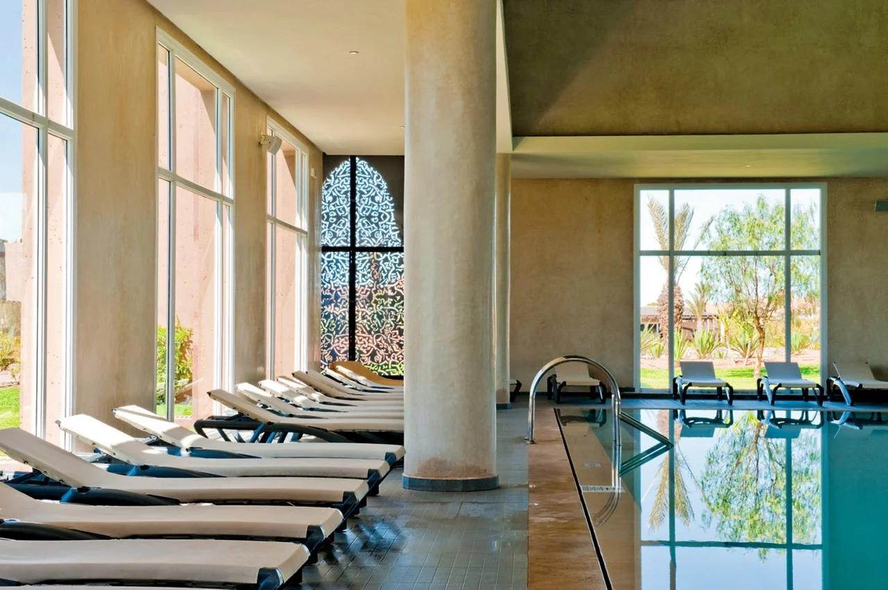 Indoor swimming pool lined with sunbeds at Clubhotel Riu Tikida Palmeraie