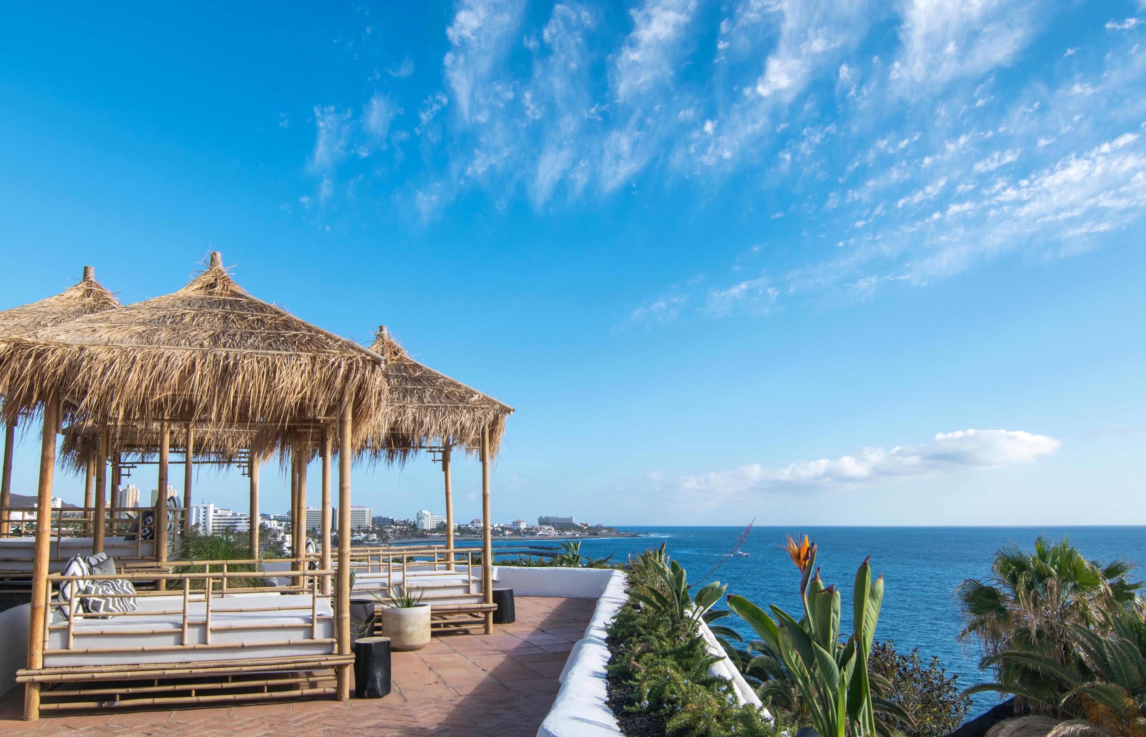 Coastal balcony lounging area with cabanas at Dreams Jardin Tropical Resort & Spa