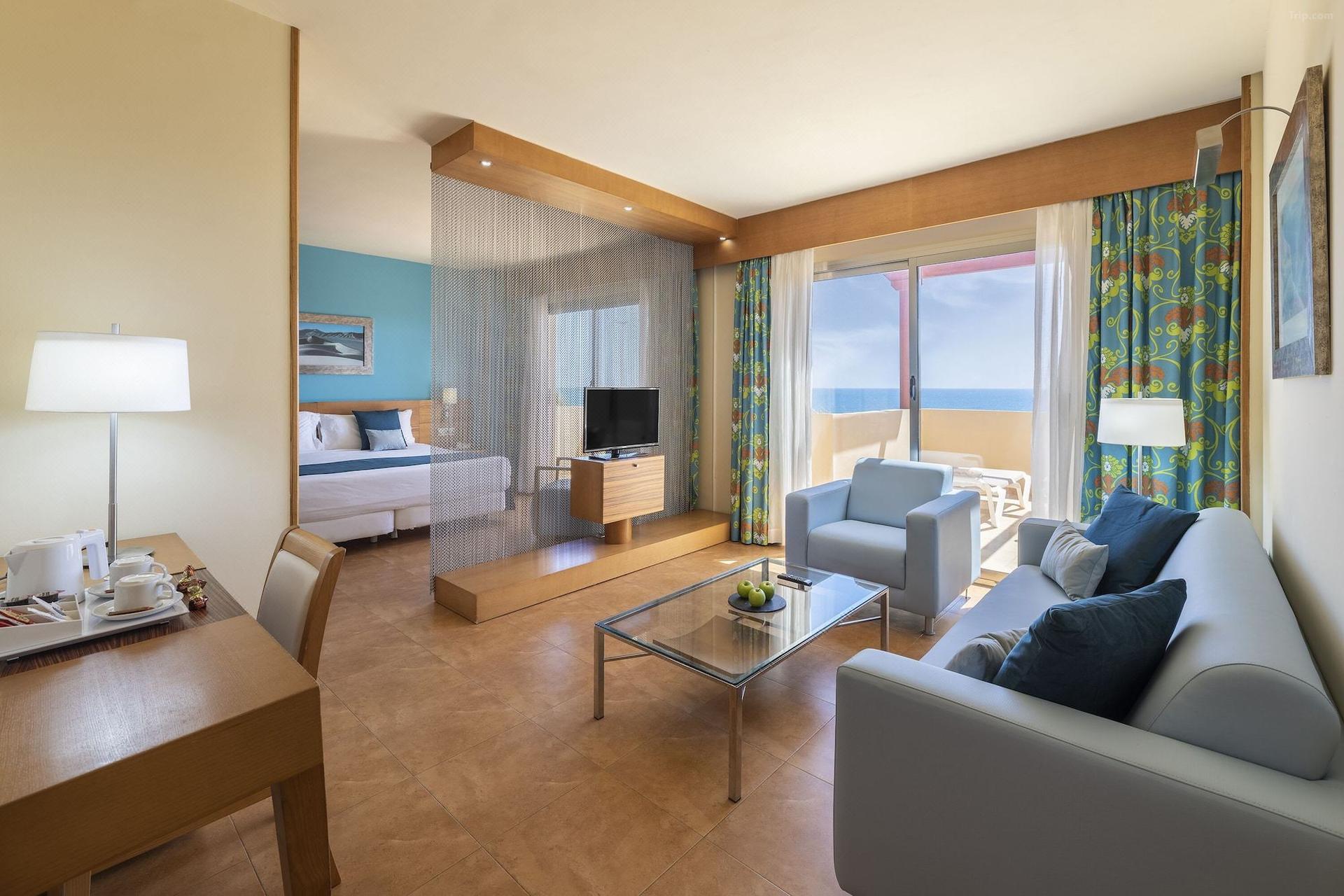 Spacious double bed suite with a separate living room and balcony at Elba Carlota Beach & Convention Resort