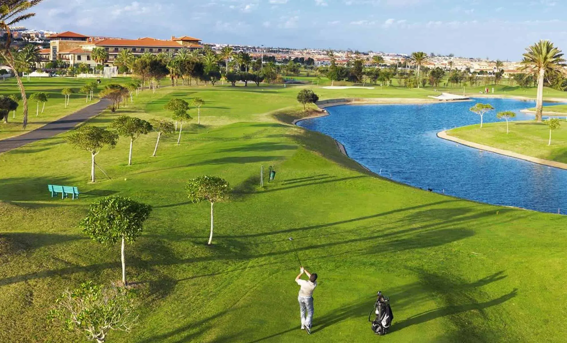 A well maintained fairway running besides a water hazard