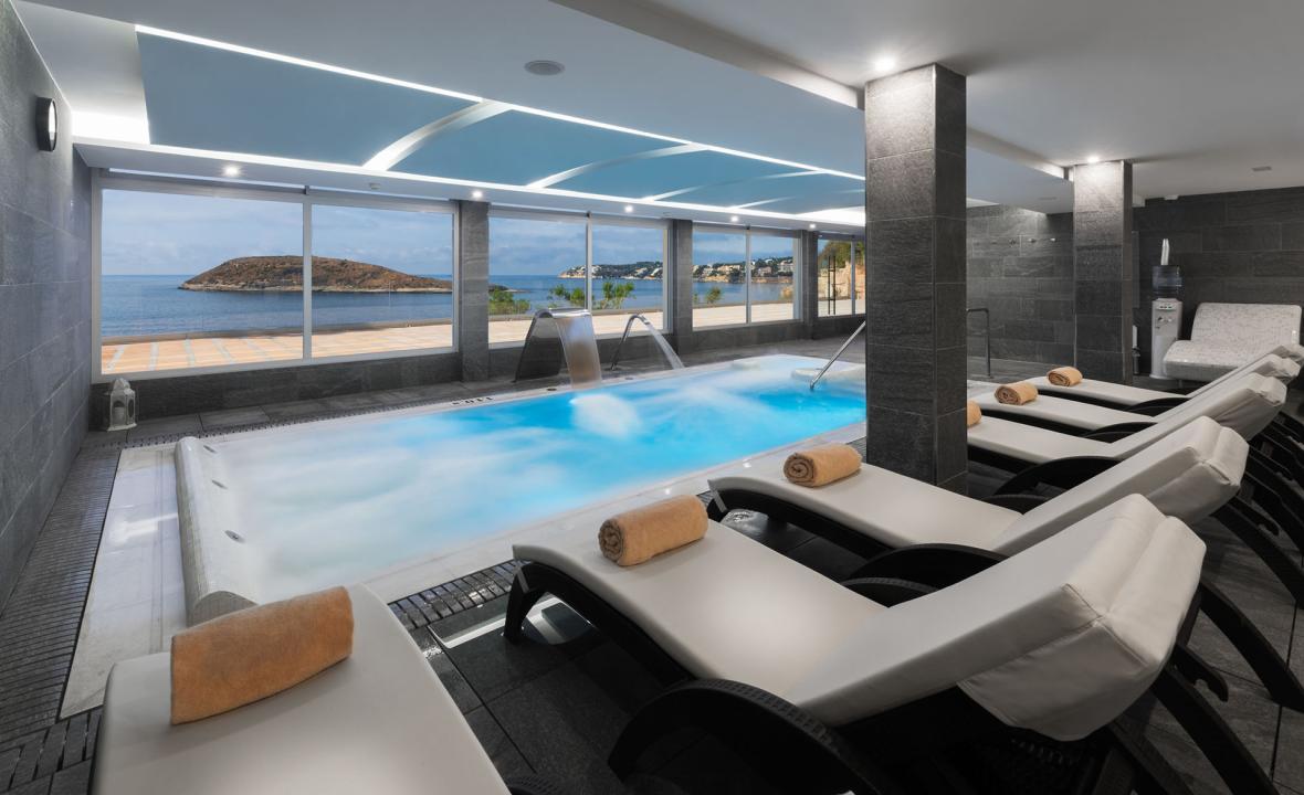 Indoor pool lined with sunbeds at Elba Sunset Mallorca & Thalasso Spa
