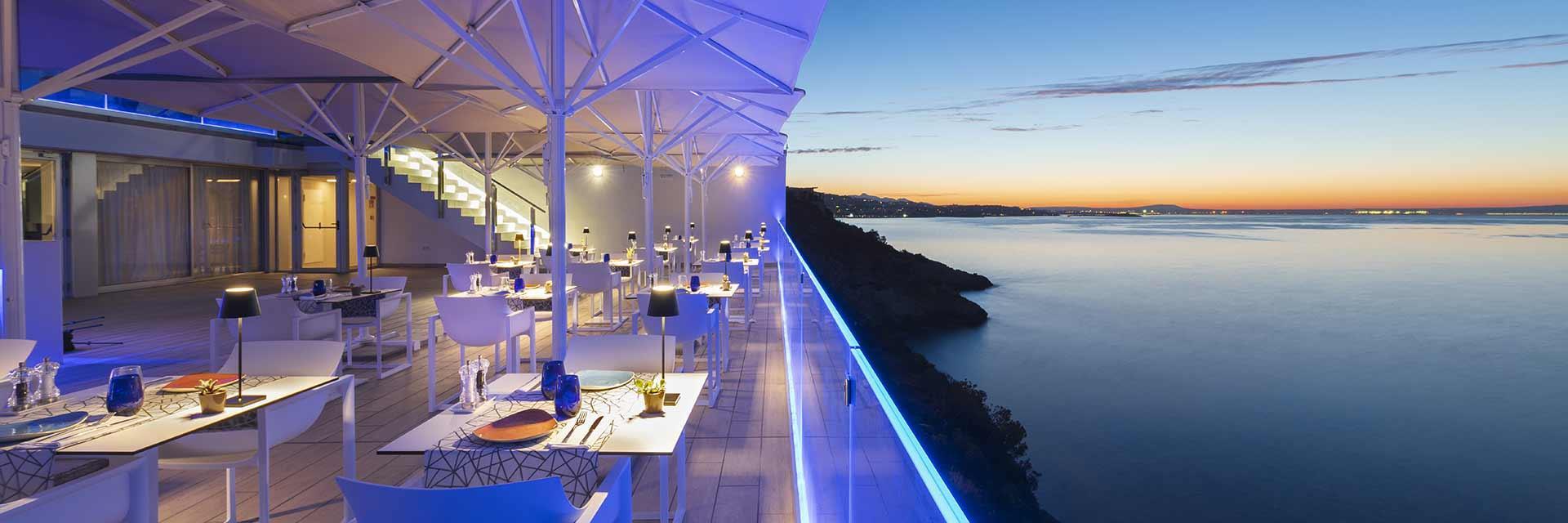 Outdoor balcony dining with coastal views at sun set