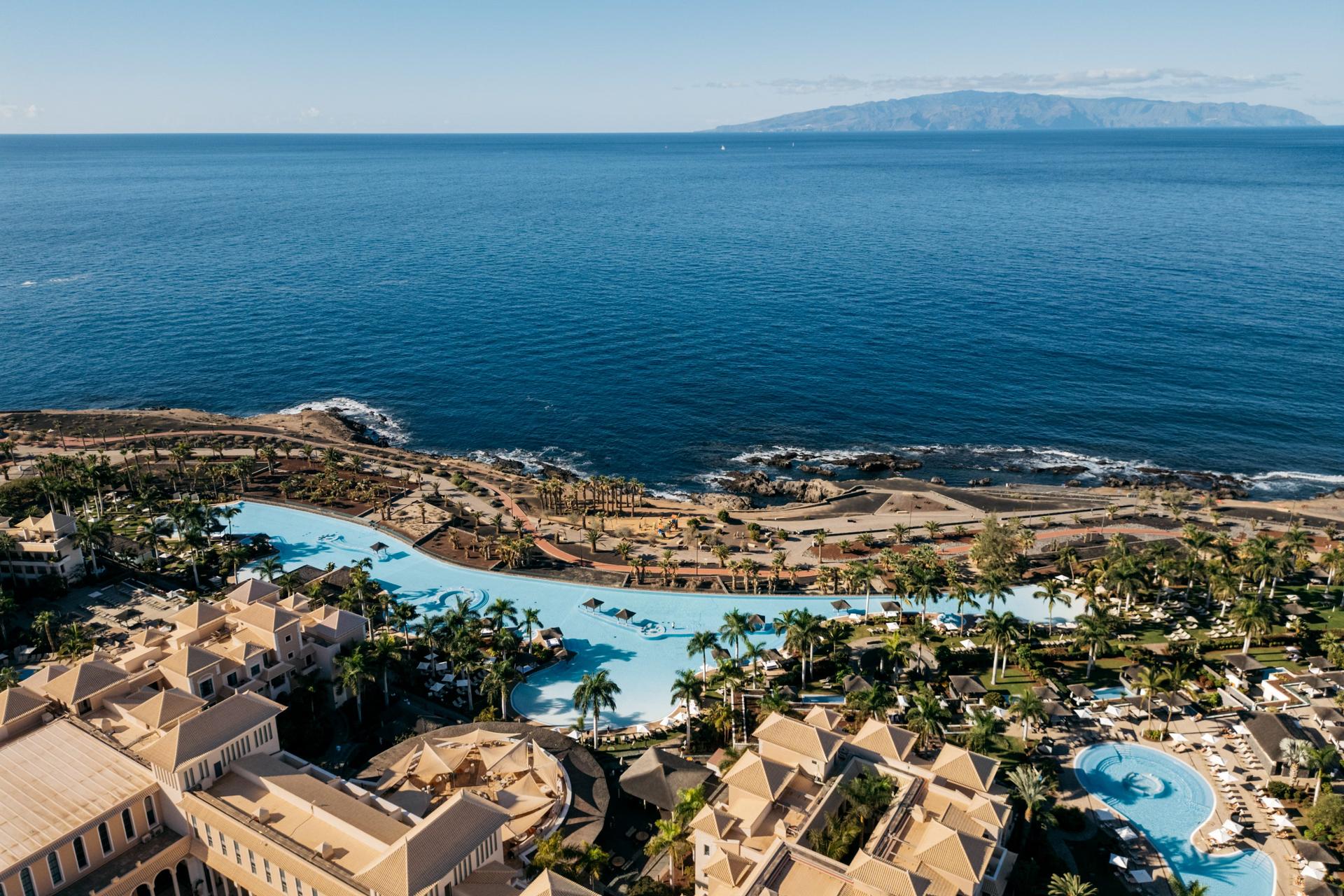Overhead view of the outdoor swimming pool at Gran Meliá Palacio de Isora with sea views