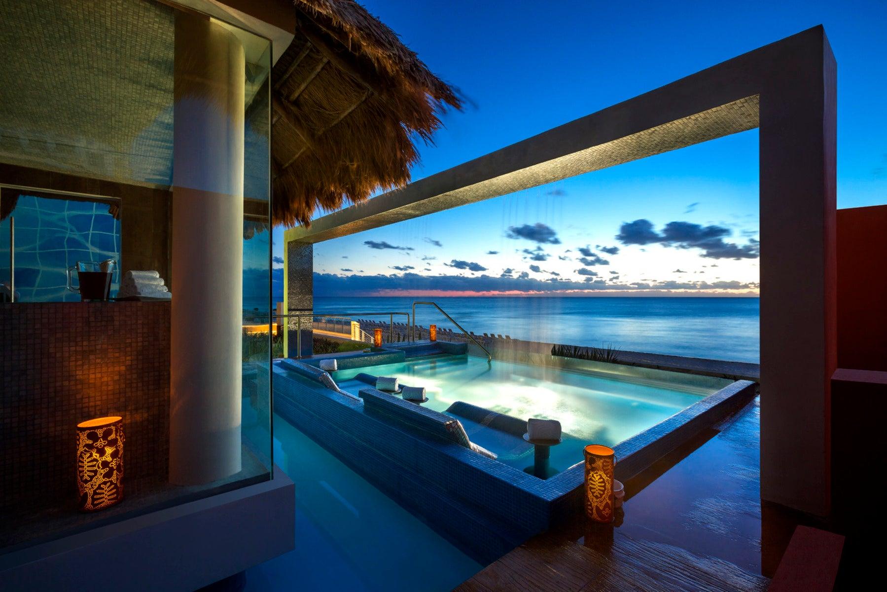 An outdoor jacuzzi on a balcony with ocean views
