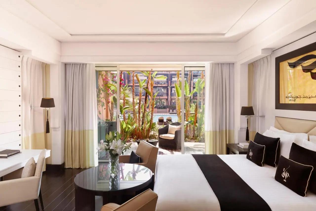 Double bed suite with a patio space leading to the outdoor pool at Hotel & Ryads Barrière Le Naoura