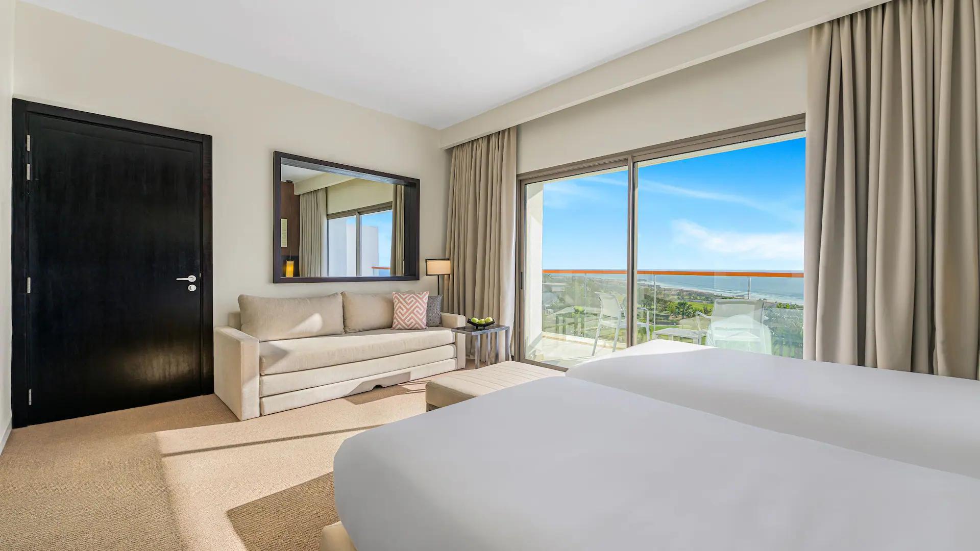 Modern double bed suite with coastal balcony views