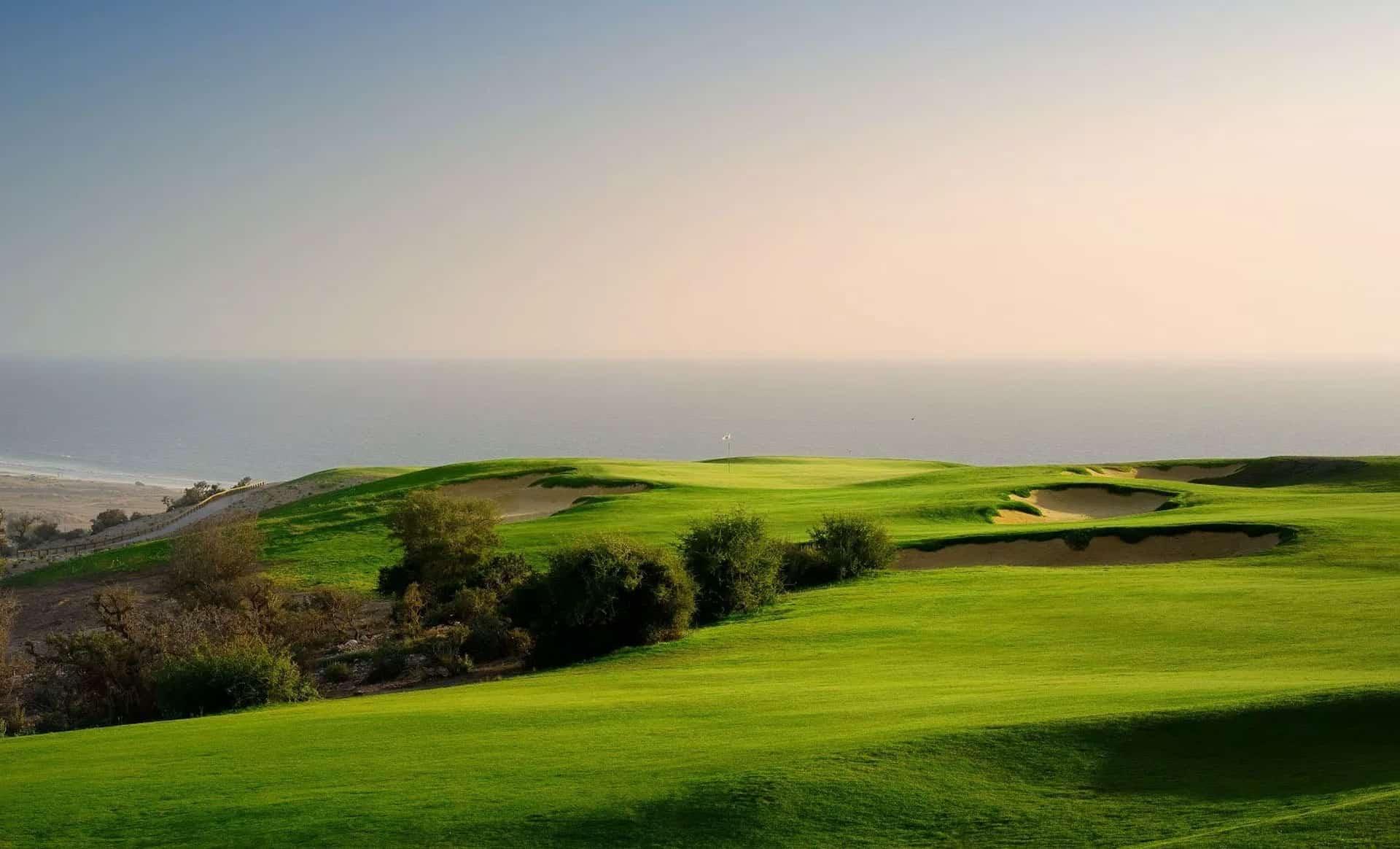 A manicured fairway with coastal views and sand bunkers at Hyatt Place Taghazout Bay