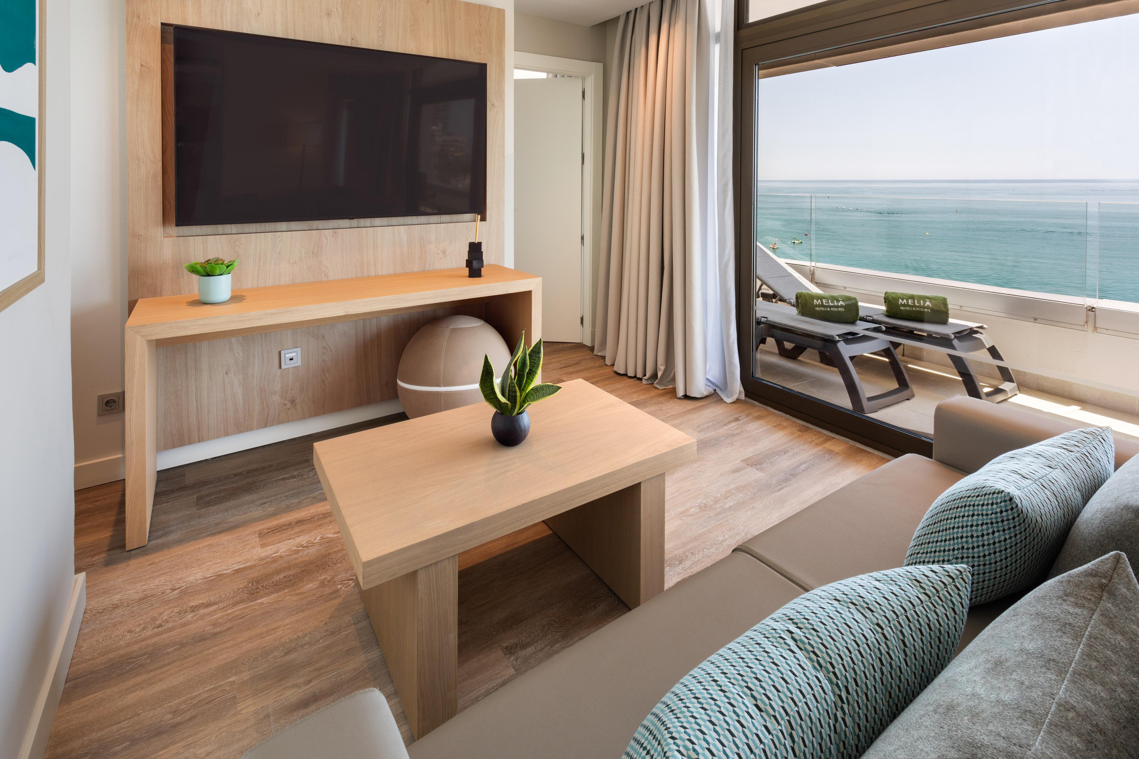 Living room as part of a suite with balcony views at Meliá Hotels & Resorts