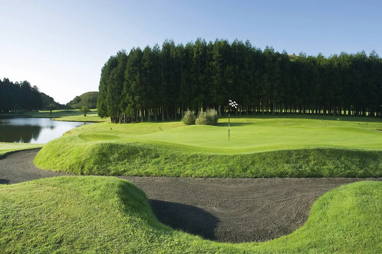 A deep sand bunker surrounding a green at Octant Hotels Furnas