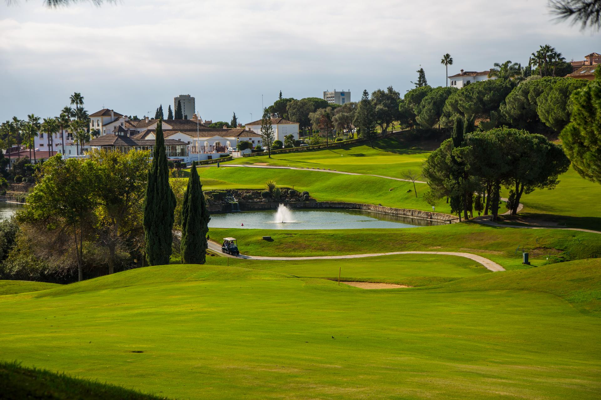 A well maintained fairway nestled with sand bunkers