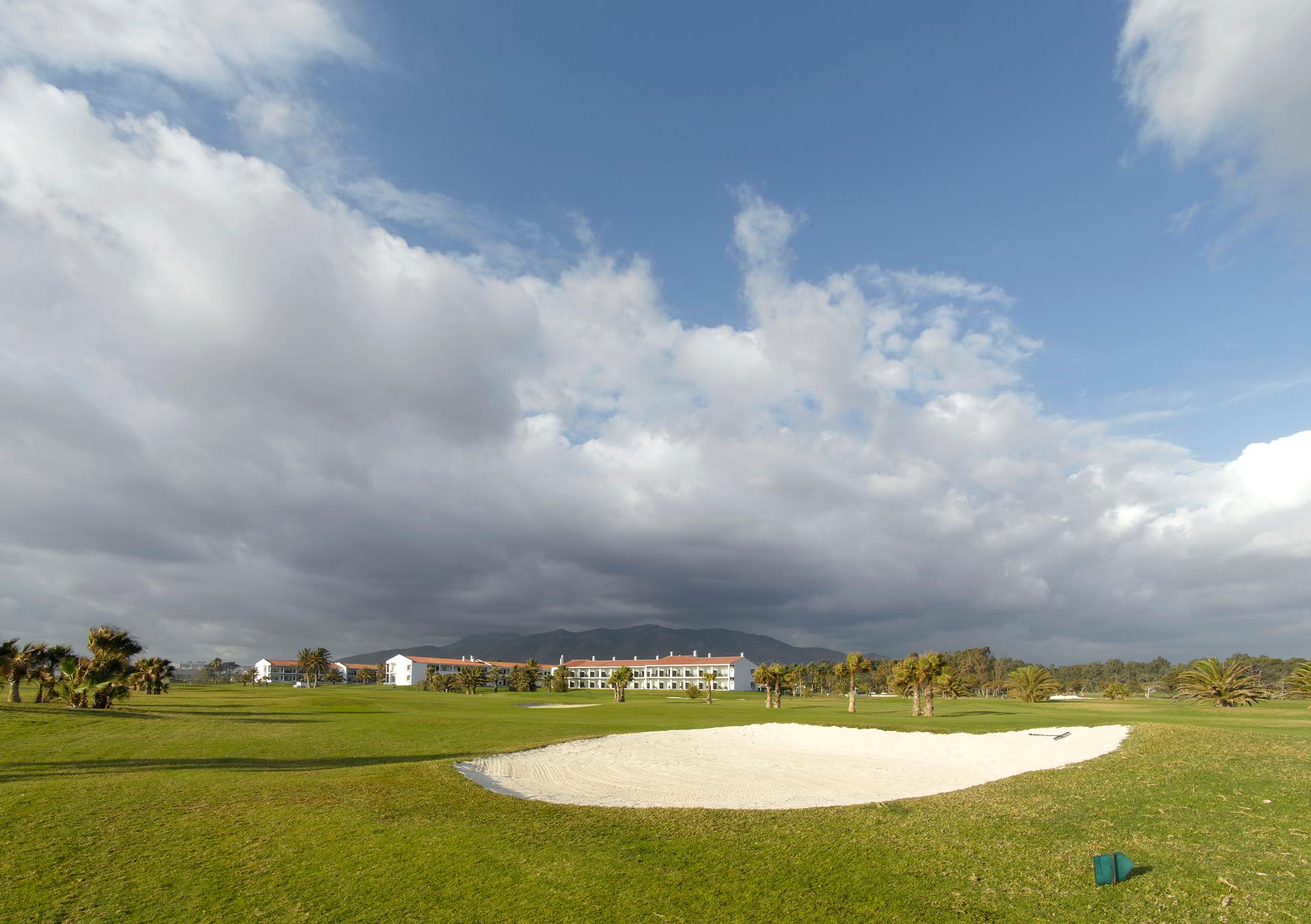 A well maintained fairway nestled with a sand bunker