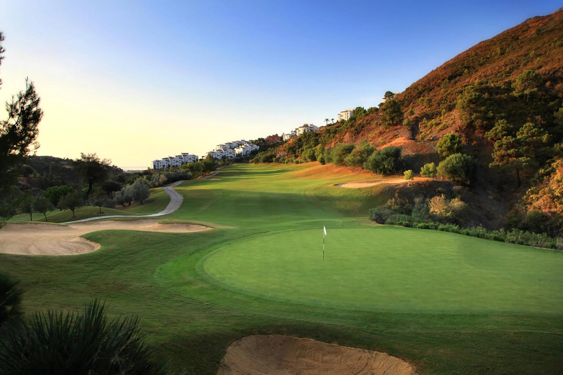 A smooth green neighbouring a sand bunker at Puente Romano Beach Resort