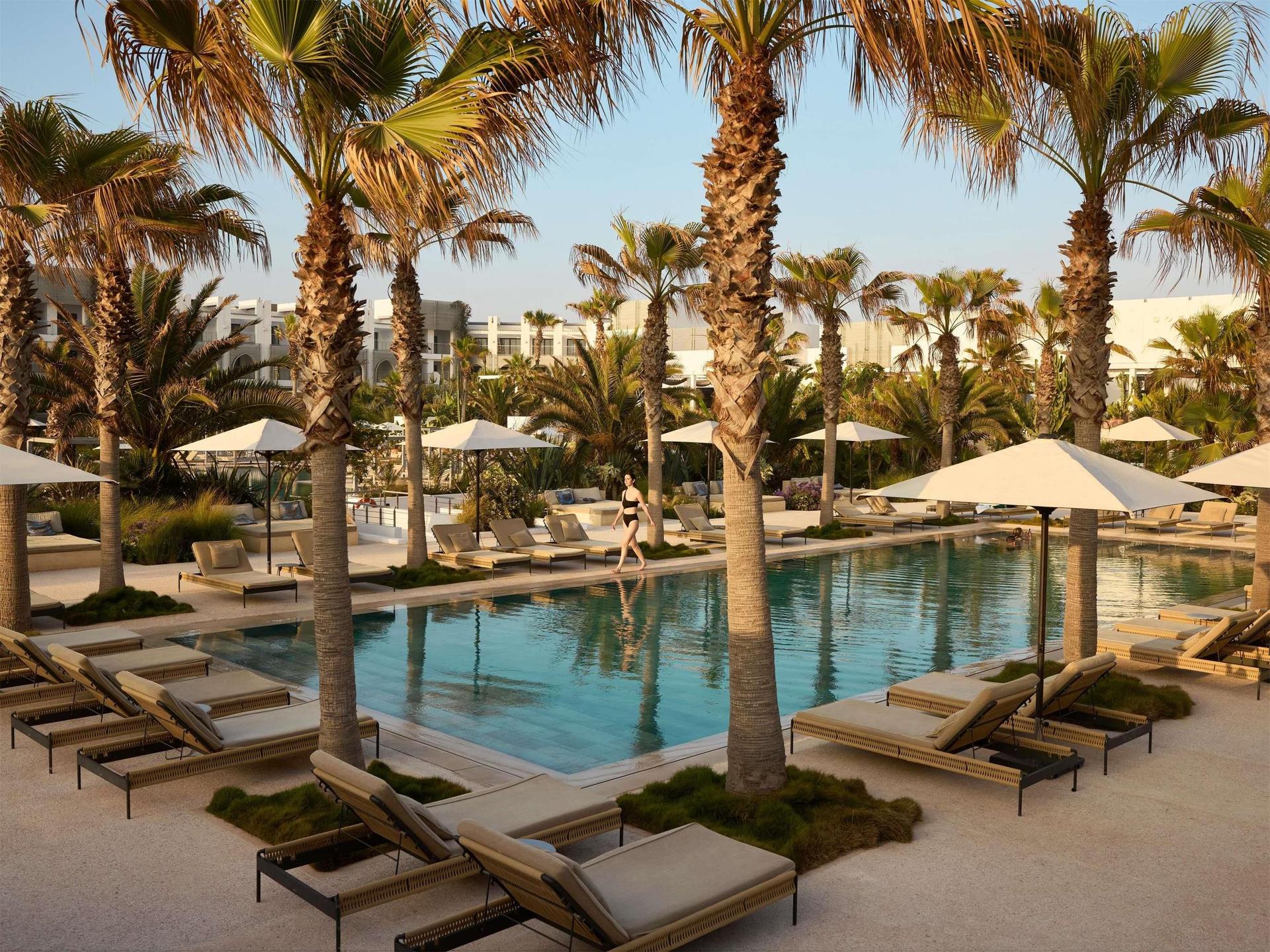 Overhead view of the outdoor swimming pool lined with palm trees at Sofitel Agadir Thalassa Sea & Spa