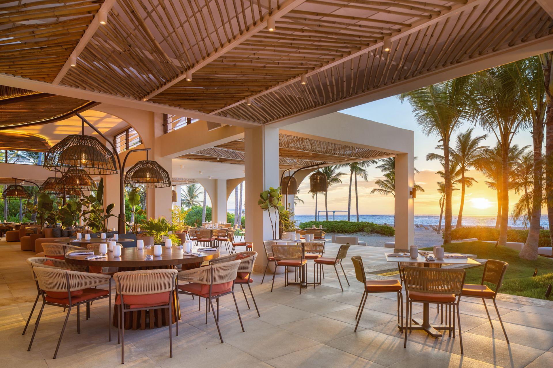 Sun setting over a sheltered outdoor dining area at The Westin Puntacana Resort & Club