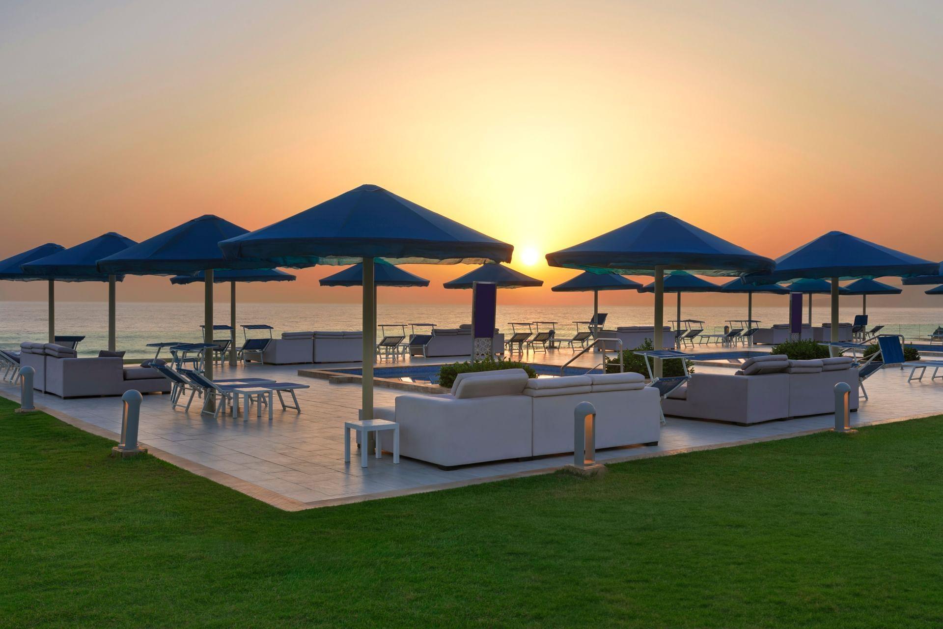 Beachfront lounging area under the sunset at White Beach Resort Taghazout