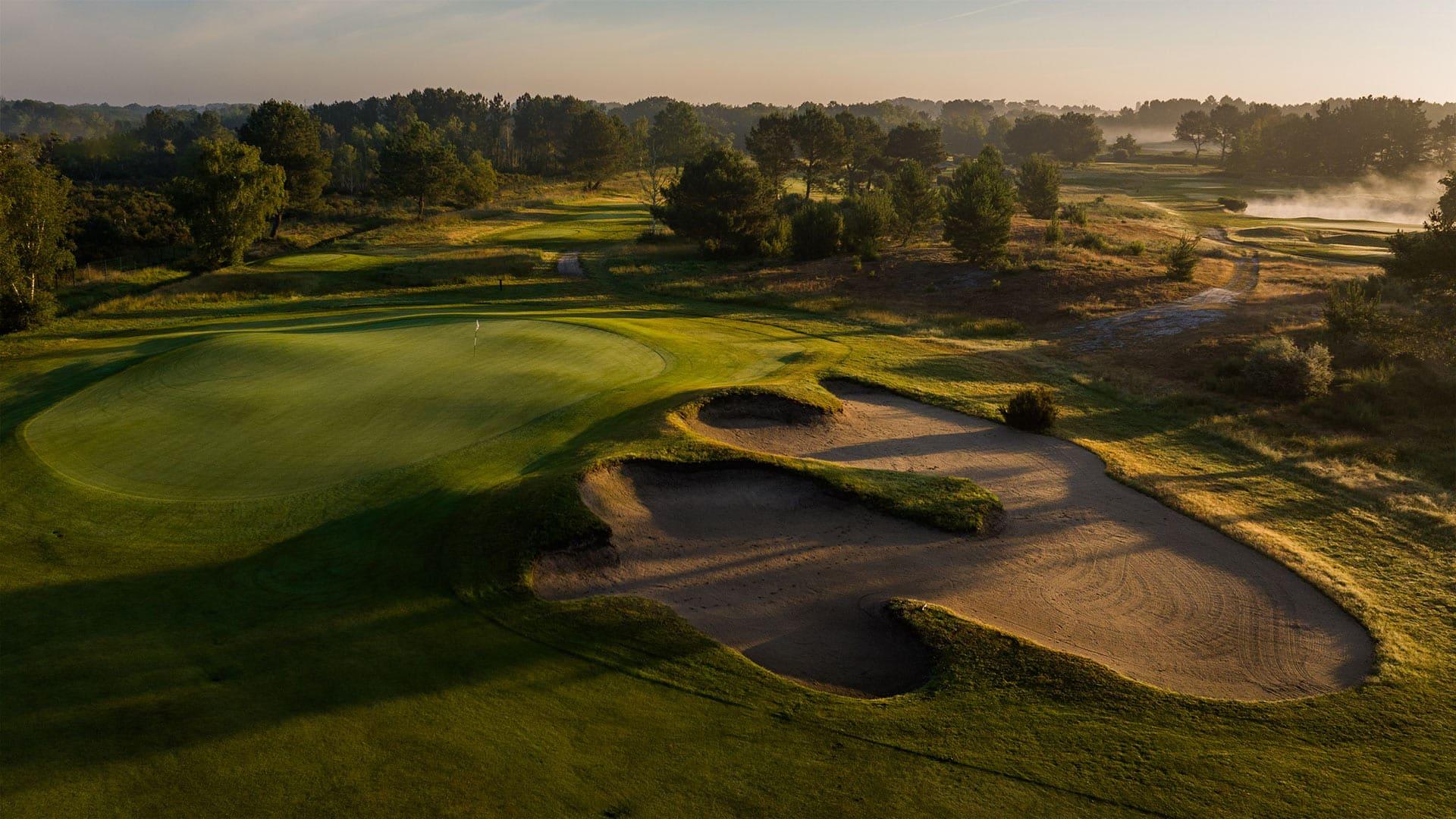 Panoramic view of a smooth green next to a large sand bunker