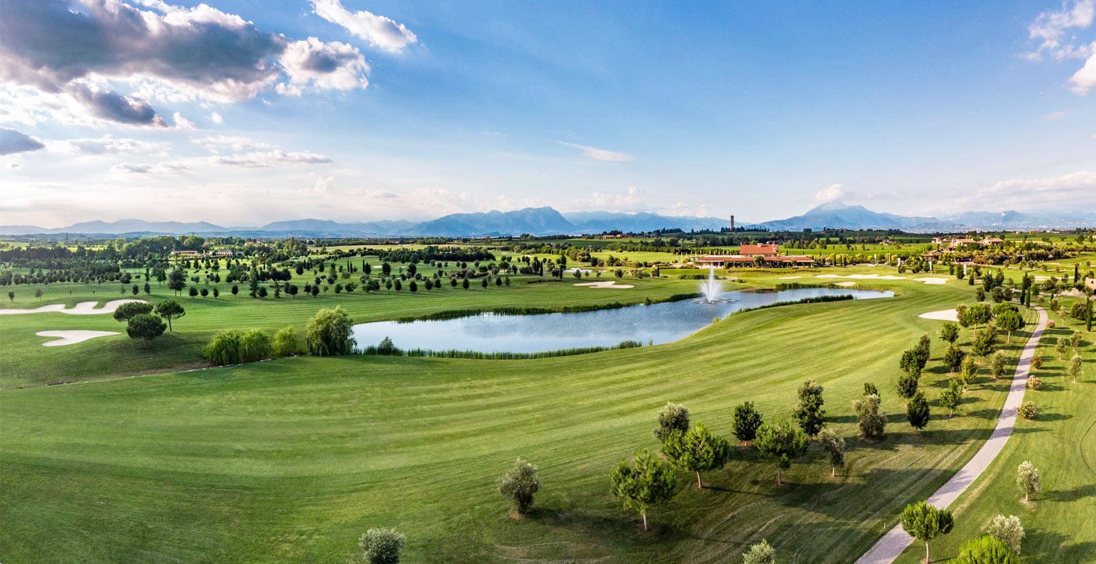 A manicured fairway running besides a water hazard