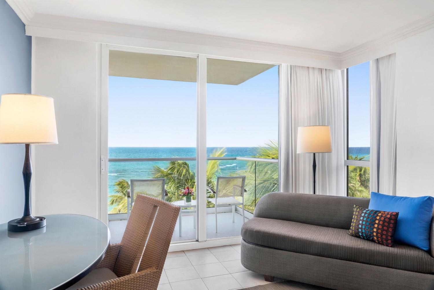 Living room with balcony views as part of a suite at Hilton Rose Hall Resort & Spa