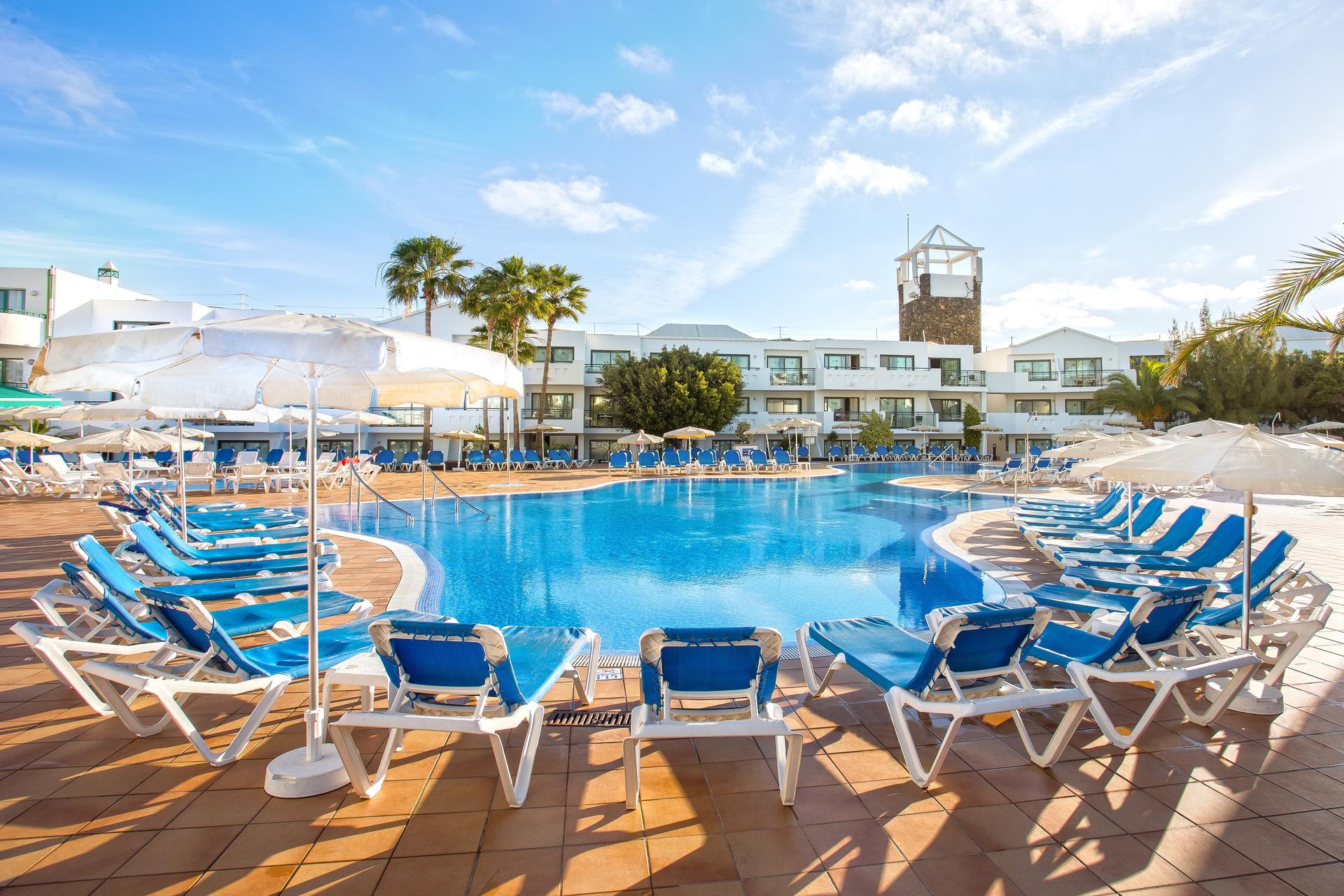 Outdoor swimming pool lined with sunbeds at THB Lanzarote Beach